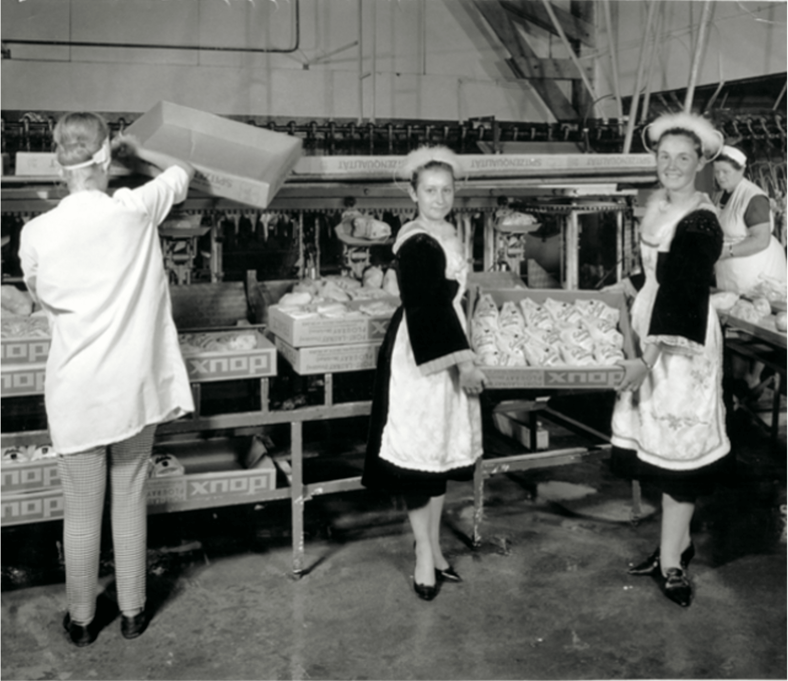 Inside the Doux factory, two workers present a box of Doux whole chicken